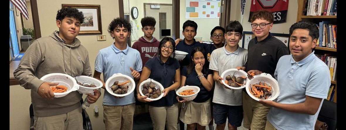 Students holding up their vegetables