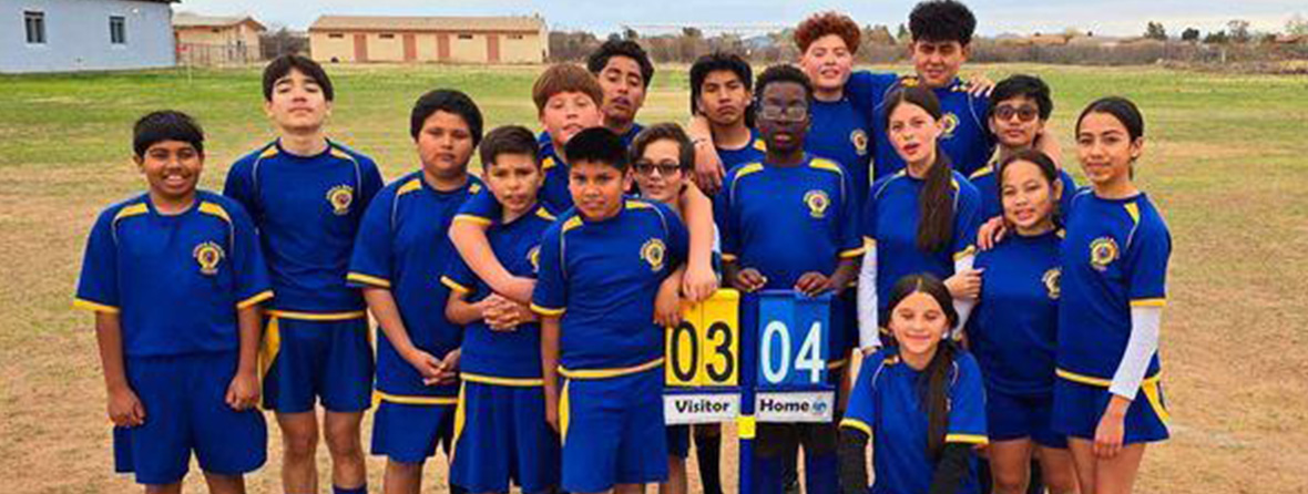 Soccer team around the score sign that reads Visitor 03, Home 04